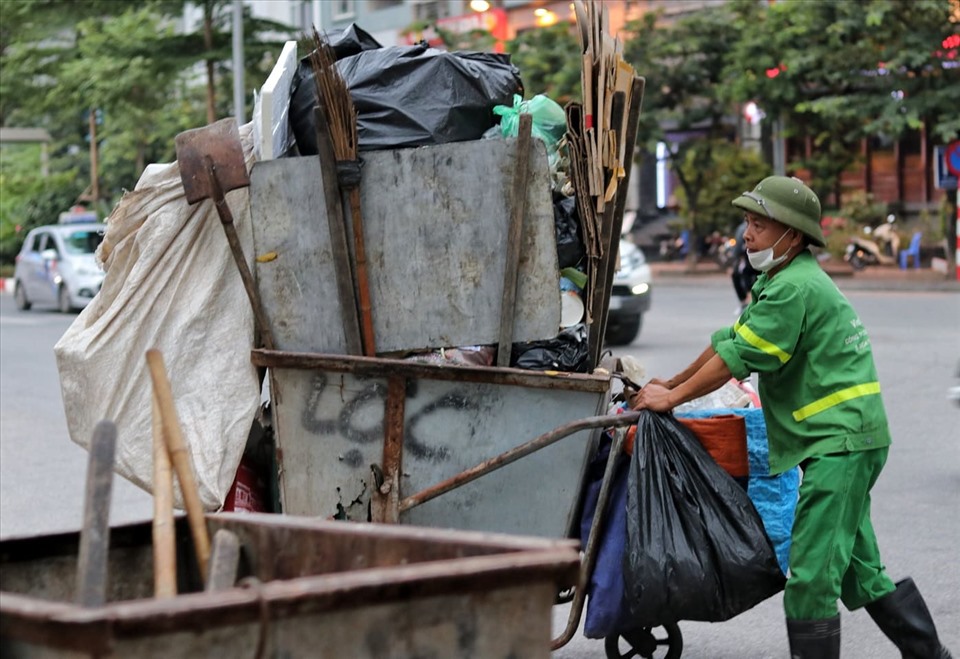 Đã 3 ngày nay, ông N.V.D (công nhân Xí nghiệp Môi trường đô thị URENCO) đã phải gồng mình đi thu dọn tại các chung cư trên đường Trần Thái Tông (Hà Nội). Do lượng rác tồn đọng quá lớn nên công việc thu gom rác của ông D cũng như nhiều công nhân khác cũng vì thế mà nặng nhọc hơn gấp nhiều lần.