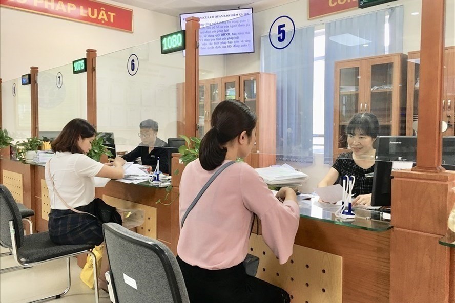 Cán bộ BHXH TP.Hà Nội hướng dẫn người dân hoàn thiện hồ sơ BHXH. Ảnh: Hải Nguyễn