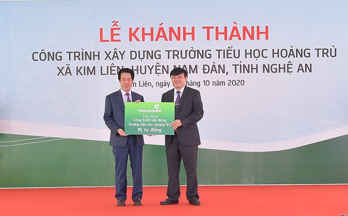 Ông Nguyễn Mỹ Hào – Thành viên HĐQT Vietcombank trao biển tượng trưng số tiền 15 tỉ đồng của Vietcombank tài trợ xây dựng Trường tiểu học Hoàng Trù. Ảnh: N.H
