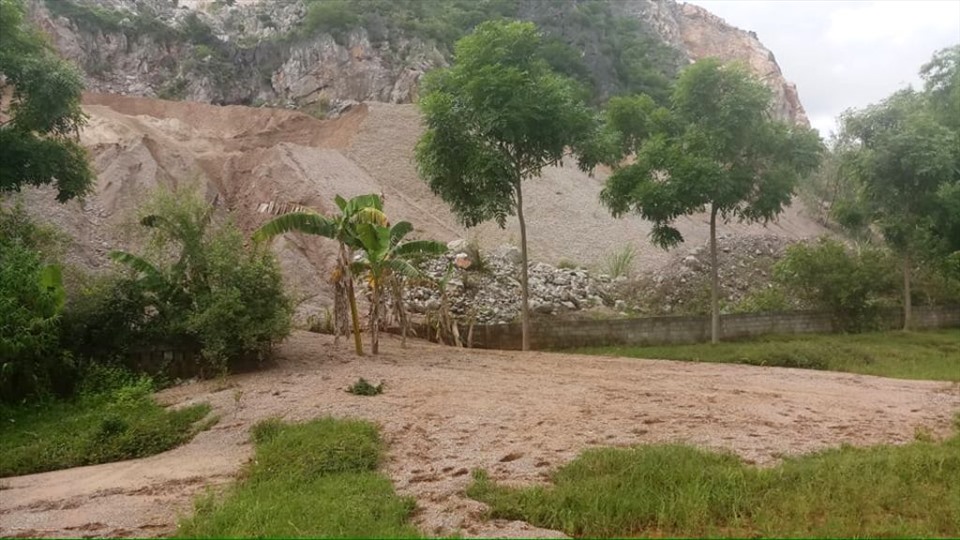 Ngoài việc nổ mìn khiến đá văng, công ty còn để đất đá chảy tràn vào nhà dân. Ảnh: Quách Du
