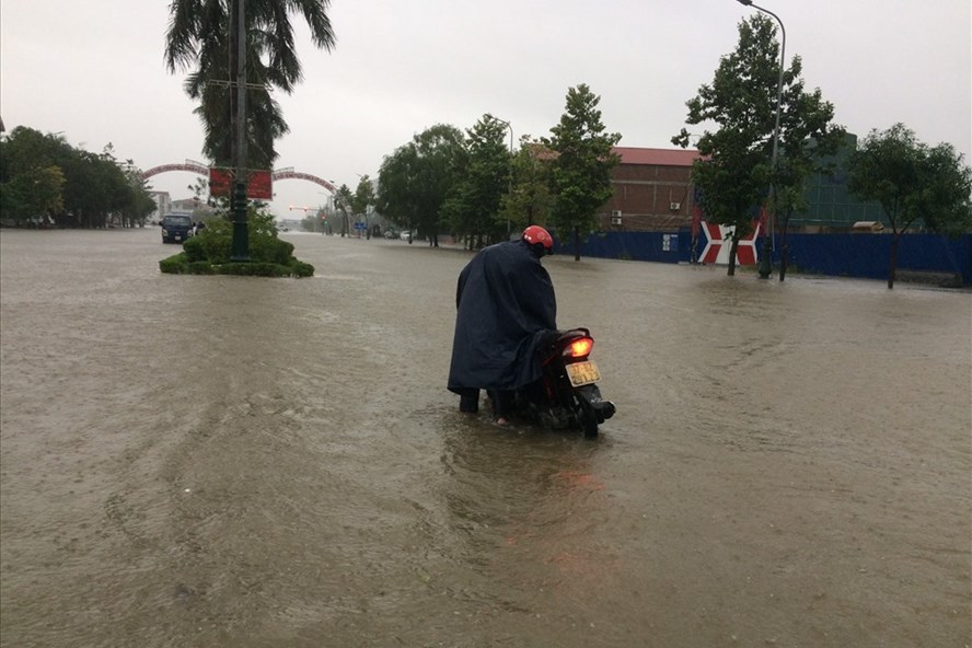 Đường phố ngập sâu, người dân TP. Vinh dắt xe 'bơi" trong biển nước. Ảnh: Trần Tuyên