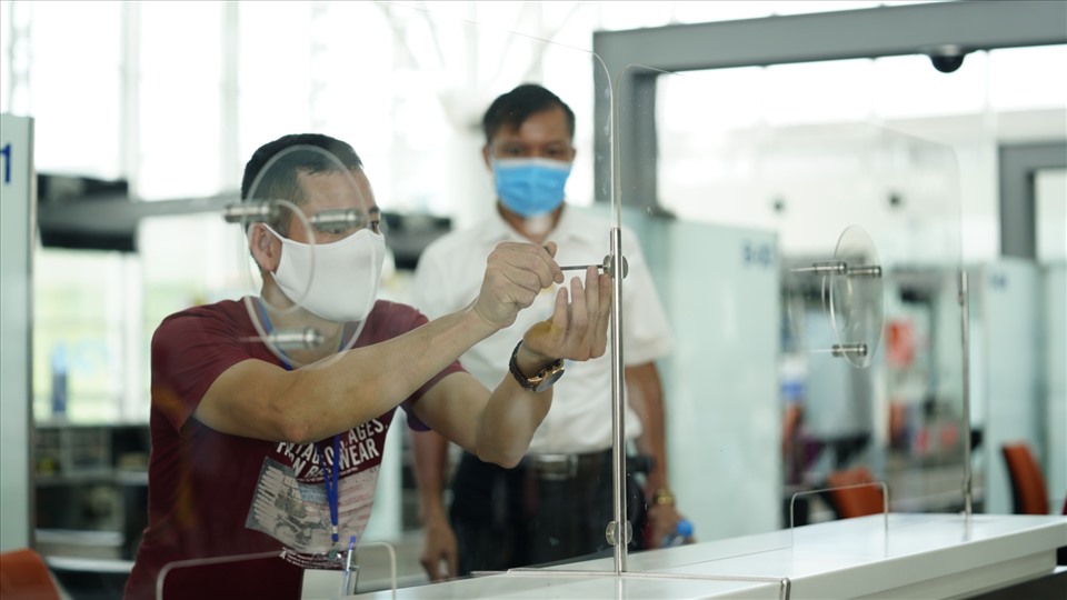 Lắp đặt màn chắn giọt bắn tại hệ thống quầy thủ tục Cảng Hàng không Quốc tế Nội Bài. Ảnh NIA
