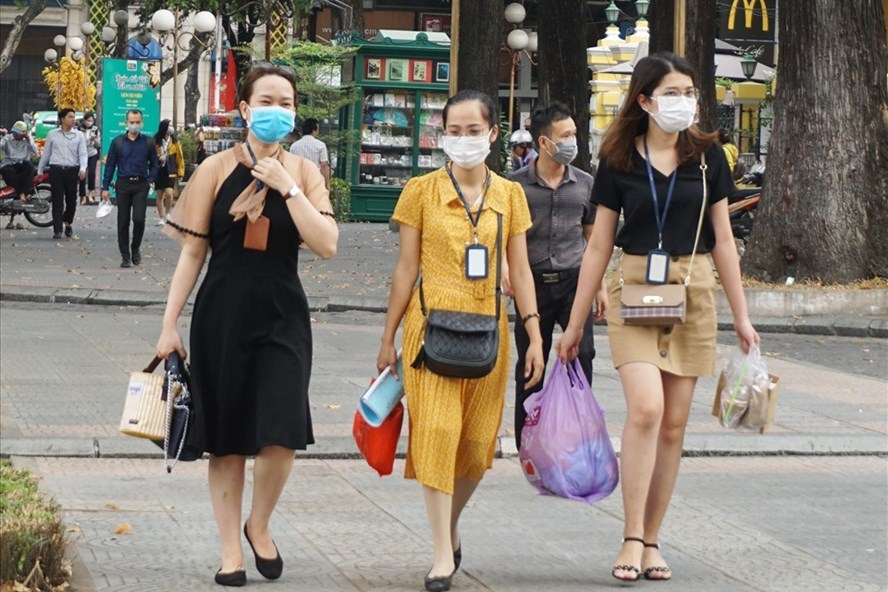 Người dân đeo khẩu trang trên đường đi bộ đến nới làm việc tại khu trung tâm TPHCM. Ảnh: Minh Quân