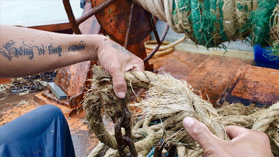 Anh Trần Sen (quê Quãng Ngãi) cho biết, gia đình anh có 2 chiếc tàu cá hành nghề giã cào. Cứ khoảng vài năm một lần, đội tàu cá nhà anh phải thay mới hệ thống dây và lưới dã cào. Mặc dù thời tiết mưa bão nhưng các thuyền viên trên tàu cá đều cố gắng hoàn thành các công việc trên tàu. Ảnh: Hữu Long