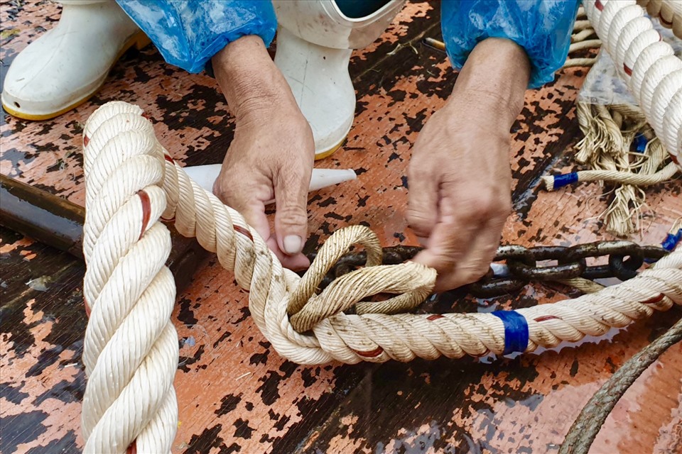 Mặc dù thời tiết mưa bão nhưng tinh thần làm việc trên tàu của các ngư dân đều hối hả và vô cùng vui vẻ. Với mọi người, việc giữ một tinh thần thoải mái, tâm lý sẵn sàng là một điều kiên quyết để vươn khơi bám biển ngay khi bão tan. Ảnh: Hữu Long