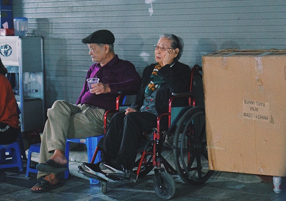 Hai cụ già ngồi quán nước bên vỉa hè (Ảnh: Yến Nhi).
