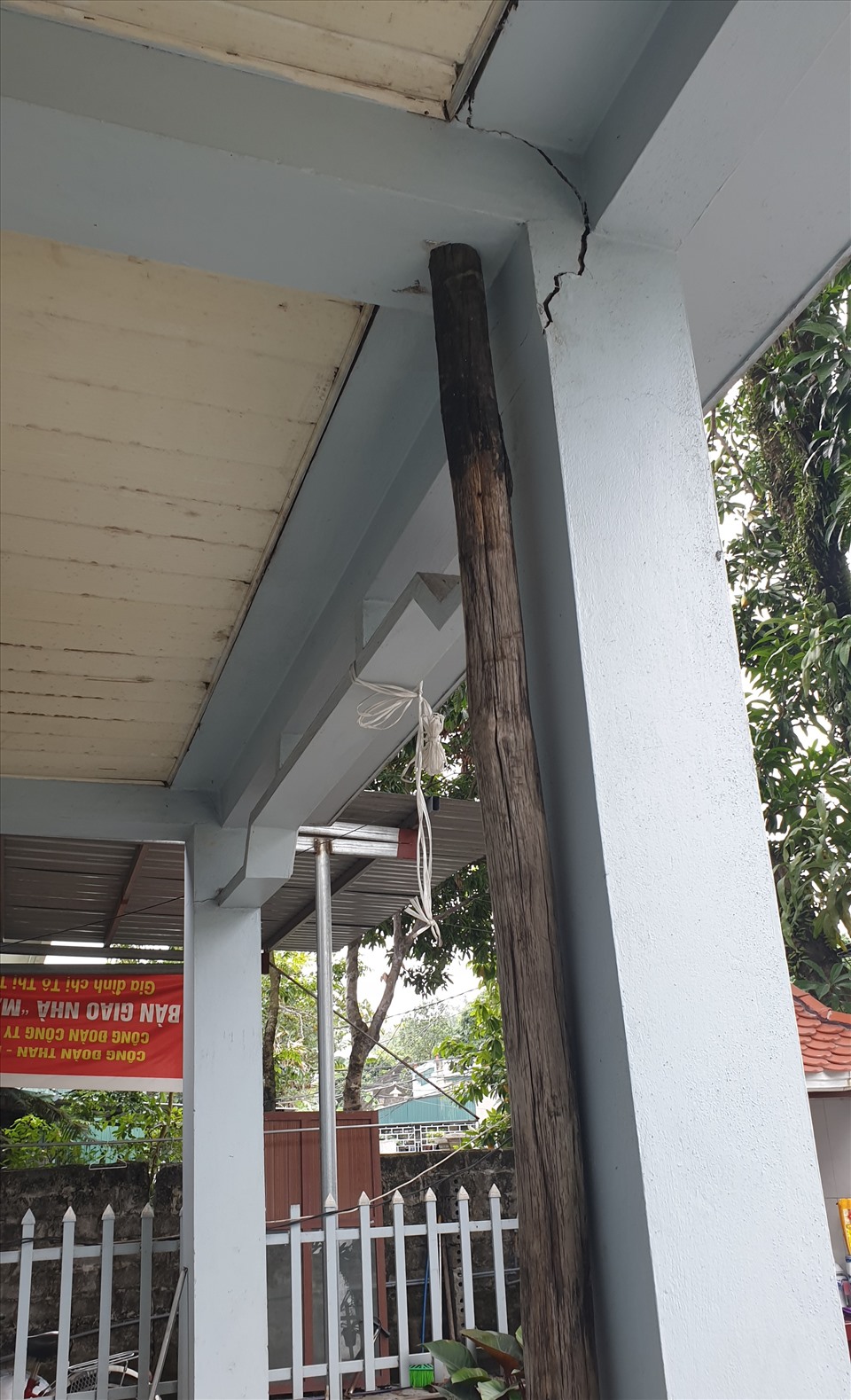 Một hộ dân phải dùng cột gỗ chống tạm xà hiên bị nứt toác do sụt lún đất. Ảnh: Nguyễn Hùng