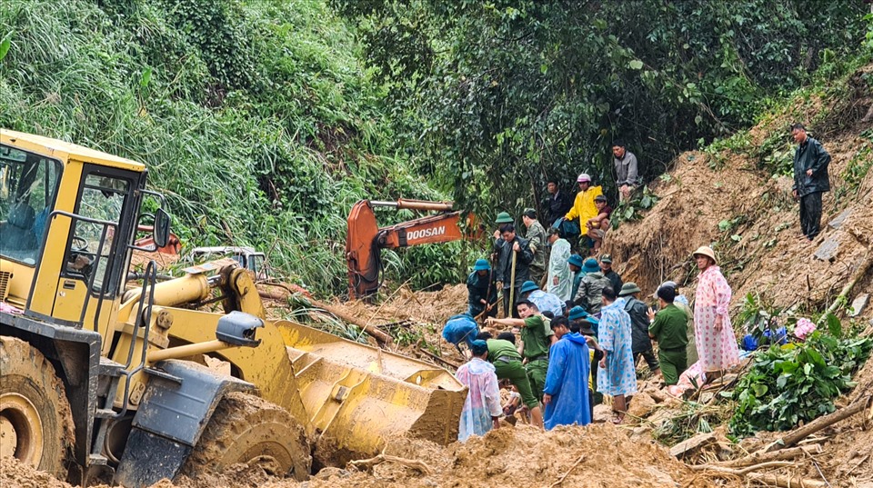 Xe cơ giới cùng lực lượng chức năng đào đất thông đường, tìm kiếm nạn nhân mất tích.