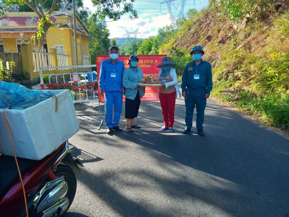 Bà Huỳnh Thị Thưởng (ngoài cùng bên phải) trao nhu yếu phẩm hỗ trợ người dân trong đợt bùng phát dịch COVID-19 vừa qua. Ảnh: NQ