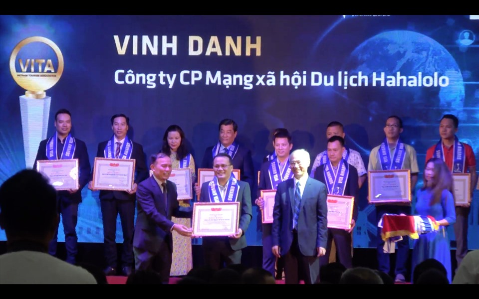 Phó Chủ tịch Hiệp hội DLVN Vũ Thế Bình và Phó Tổng cục trưởng TCDL Ngô Hoài Chung trao Bằng khen cho Hahalolo. Ảnh: VP