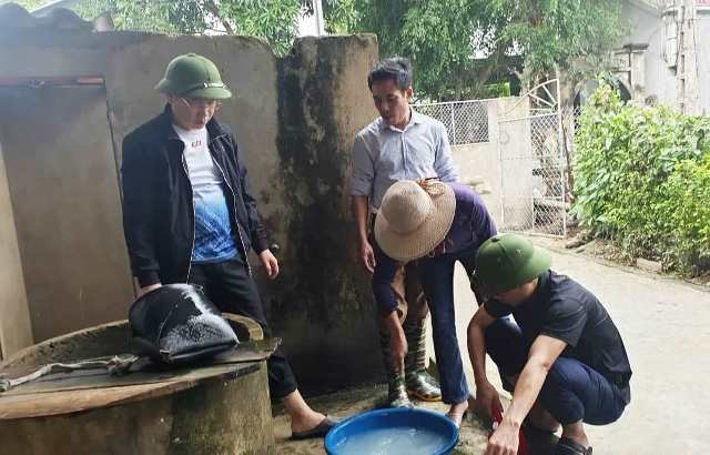 Cán bộ y tế xử lý khử khuẩn giếng nước bị ngập lụt. Ảnh: TĐM.