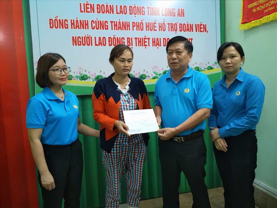Chủ tịch LĐLĐ tỉnh Long An - ông Nguyễn Văn Quí - trao 5 triệu đồng cho gia đình người lao động Võ Văn Thoại tử nạn do bão lũ. Ảnh: K.Q
