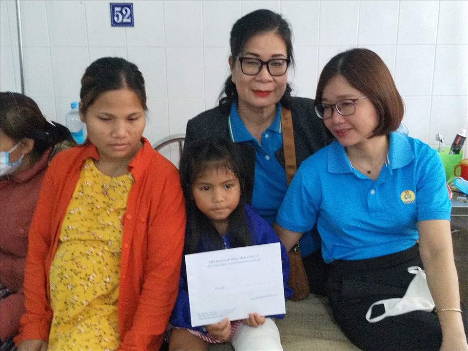 Bà Phạm Thị Quyên - Phó Chủ tịch LĐLĐ tỉnh Long An (bên phải) - thăm hỏi và hỗ trợ cháu Hồ Hà My. Ảnh: K.Q