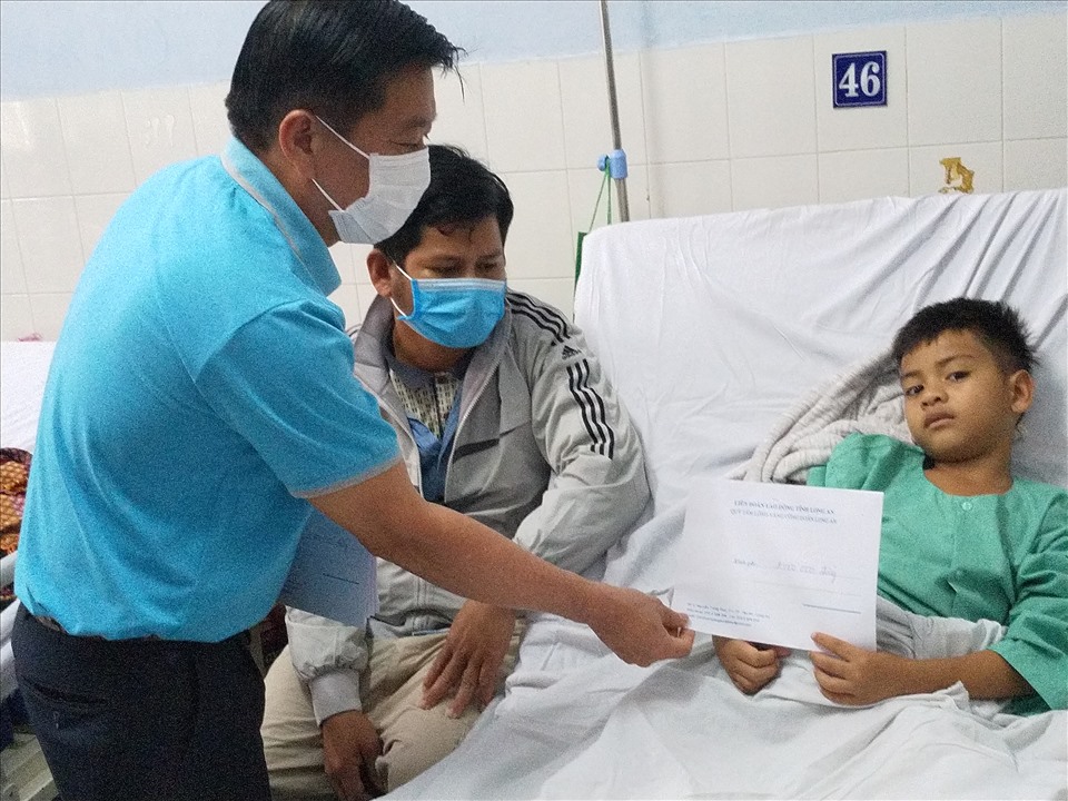 Chủ tịch LĐLĐ tỉnh Long An - ông Nguyễn Văn Quí - thăm và hỗ trợ cháu Đinh Hoàng Thái. Ảnh: K.Q