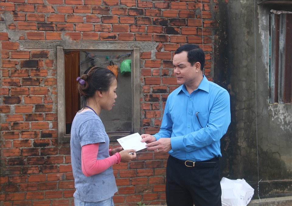 Chủ tịch Nguyễn Đình Khang  trao tiền hỗ trợ cho gia đình đoàn viên Công đoàn bị thiệt hại về nhà ở do bão số 9 tại tỉnh Quảng Nam. Ảnh: TLĐ
