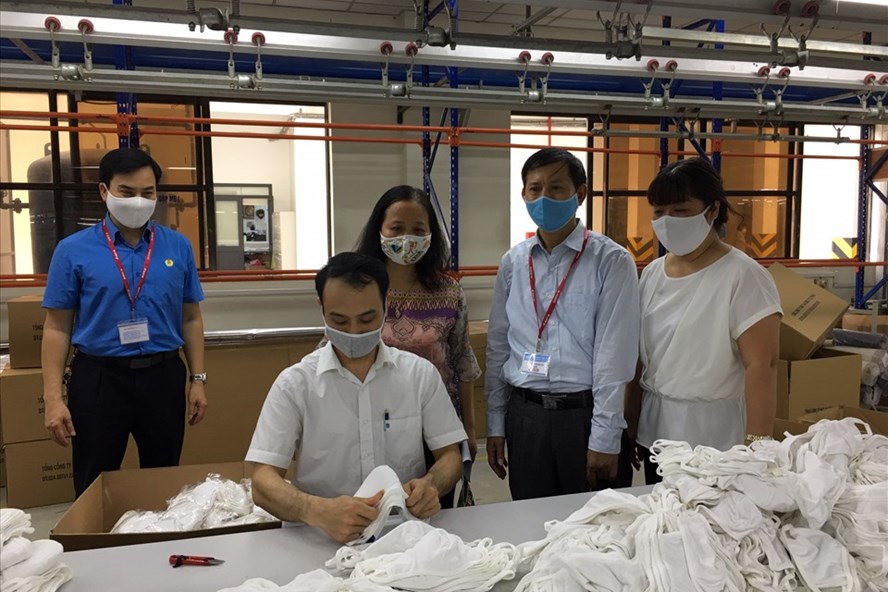 Cán bộ Tổng Liên đoàn Lao động Việt Nam, Công đoàn Dệt may Việt Nam thăm những giáo viên Trường Cao đẳng nghề Long Biên bị ảnh hưởng do COVID-19 phải tạm nghỉ dạy được bố trí làm tại dây chuyền sản xuất khẩu trang hồi tháng 3.2020. Ảnh: Hải Anh