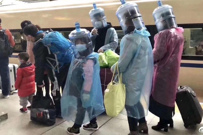 Một gia đình đội chai nước nhựa lên đầu để phòng dịch COVID-19. Ảnh: Weibo.