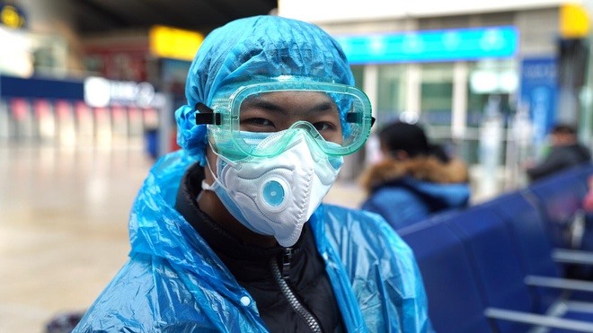 Người đàn ông tự bảo vệ mình bằng cách mang khẩu trang, kính phẫu thuật, áo mưa nhằm tránh nguy cơ lây nhiễm COVID-19 từ người khác.
