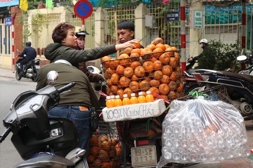 Tiểu thương thu tiền triệu mỗi ngày nhờ bán nước cam ép. Ảnh: LN Tiểu thương thu tiền triệu mỗi ngày nhờ bán nước cam ép. Ảnh: LN