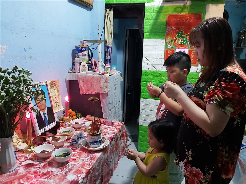 Vợ con anh Tâm thắp hương cho chồng, bố. Ảnh Nam Dương