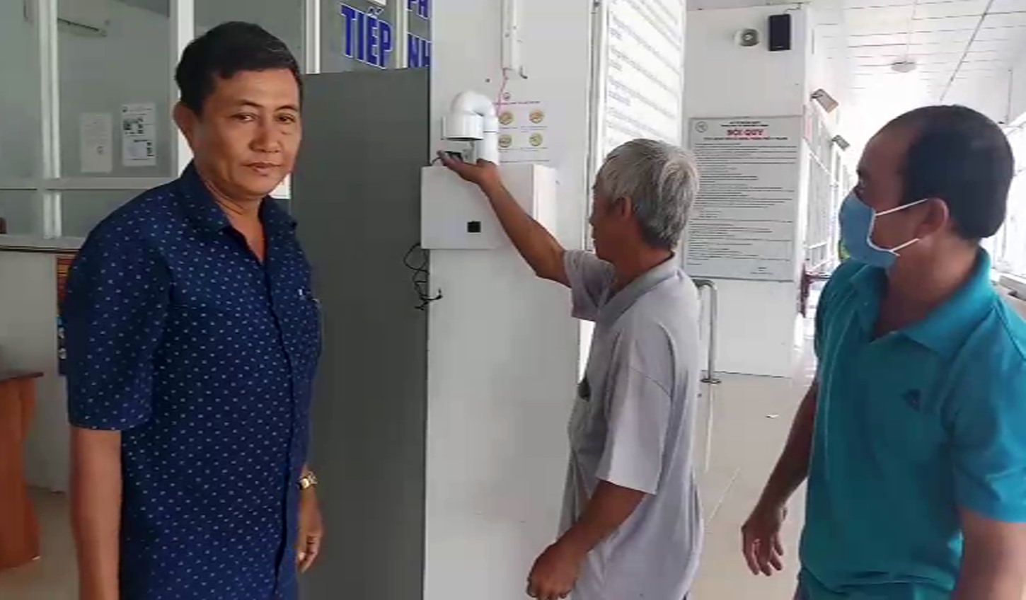 Người dân sử dụng thiết bị sát khuẩn tay tự động tại Khoa khám bệnh Trung tâm y tế TP.Vị Thanh. Ảnh: Tr.L
