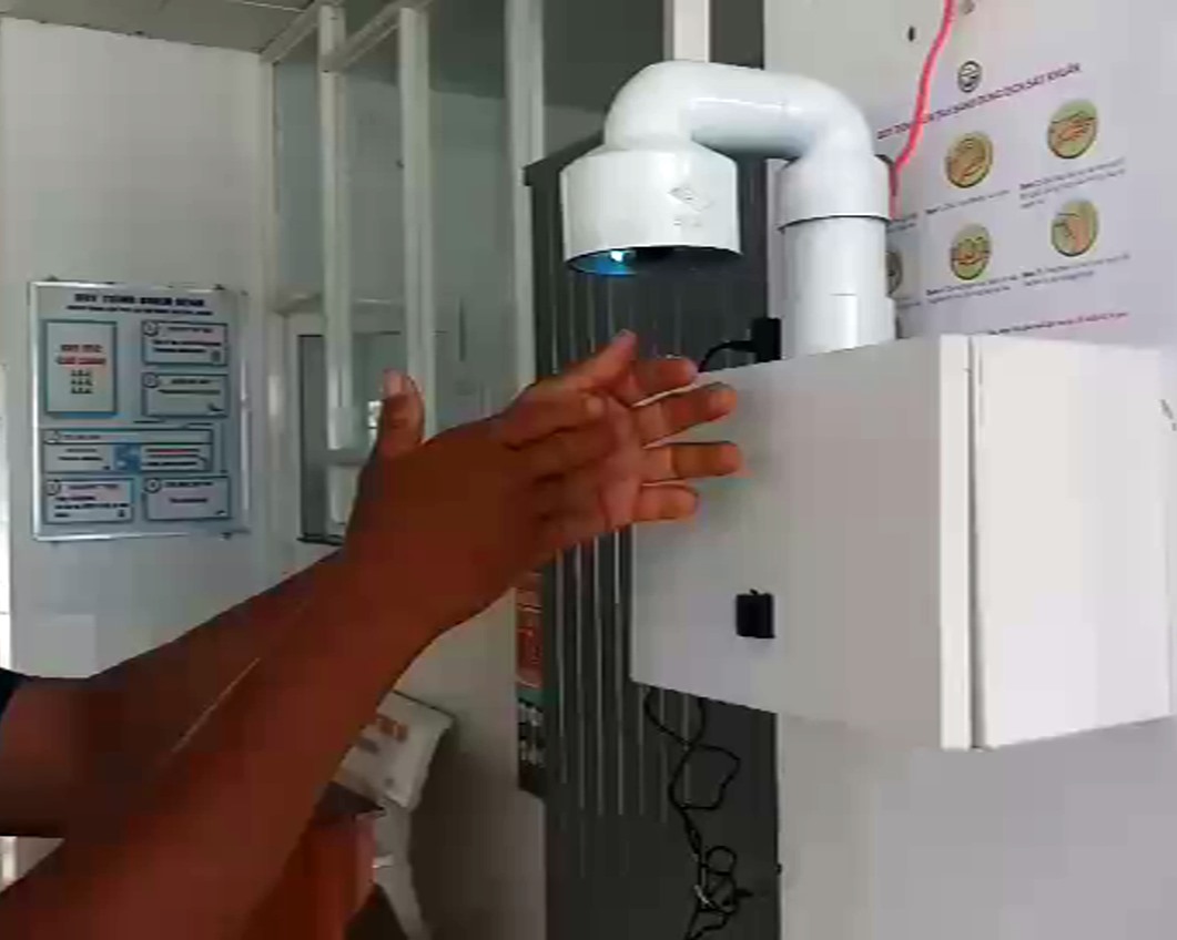 Khi đưa tay vào, dung dịch sát khuẩn được phun ra dạng sương, người dân thích thú chà xát dung dịch khắp bàn tay và cũng cảm thấy mùi thơm dễ chịu. Ảnh: Tr.L
