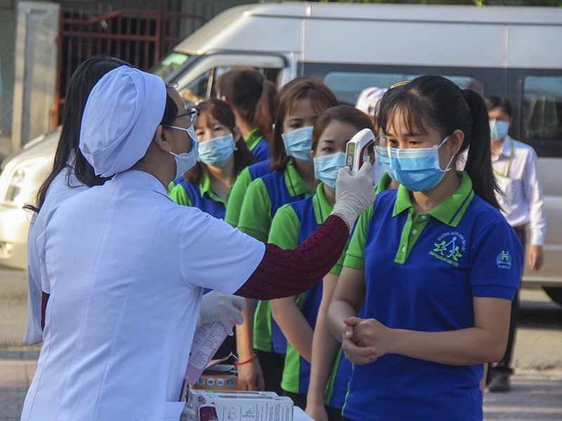 Giáo viên được kiểm tra thân nhiệt trước lúc vào trường vào sáng 3.2. Ảnh: P. Thành