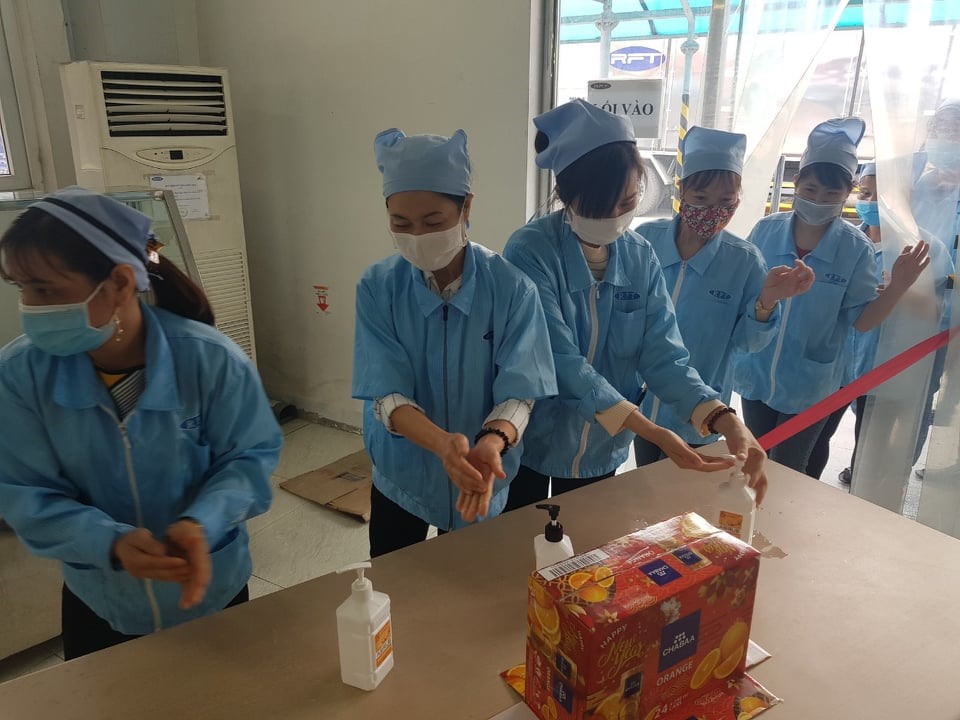 Công nhân sát khuẩn tay trước khi vào làm việc.