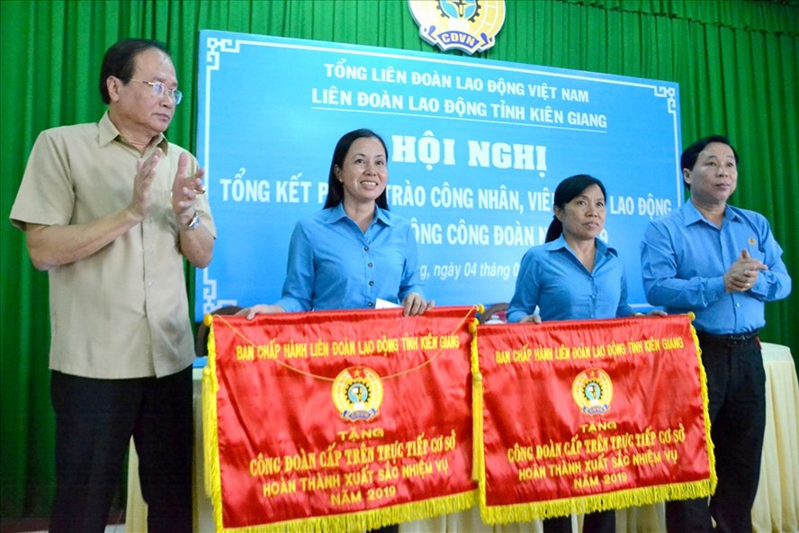 Trưởng Ban Dân vận Tỉnh ủy Kiên Giang - Lâm Hoàng Sa (ngoài cùng, bên trái) và Chủ tịch LĐLĐ Kiên Giang - Trần Thanh Việt tặng cờ thi đua LĐLĐ tỉnh cho 2 Công đoàn trực tiếp cấp trên cơ sở có thành tích xuất sắc năm 2019. Ảnh: LT