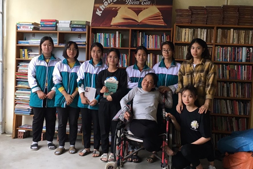 Nguyễn Lan Hương (người ngồi xe lăn) cùng các bạn nhỏ đến đọc sách tại thư viện. Ảnh: PV