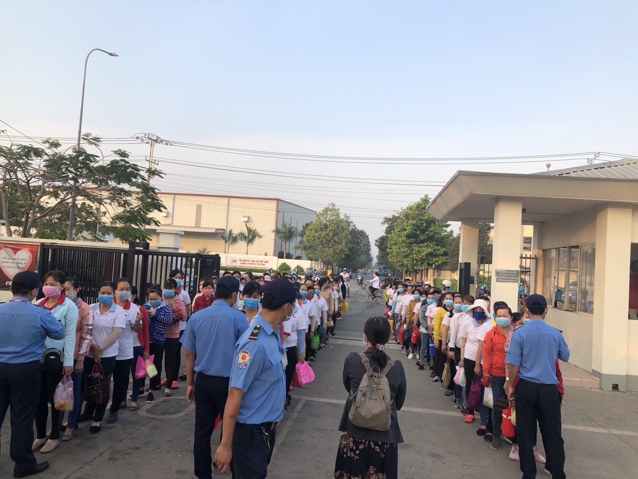 Cán bộ công đoàn tham gia đo thân nhiệt người lao động trước khi vào ca. Ảnh: K.Q