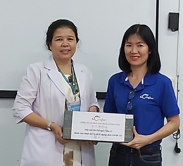 Bà Nguyễn Thị Ngọc Tuyết, Chủ tịch Công đoàn Công ty Cổ phần Xây dựng Coteccons trao tặng 30 thùng sữa cho các y, bác sĩ, nhân viên y tế Bệnh viện Nhiệt đới TP.Hồ Chí Minh. Ảnh Nam Dương