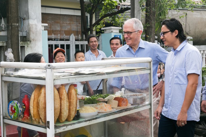 Xếp hàng chờ mua bánh mì, Thủ tướng Úc trả tiền và cảm ơn người bán bánh mì. Thủ tướng Turnbull nói: “Người Úc thưởng thức món ăn Việt Nam hàng ngày và đây chính là một trong những đóng góp tích cực của gần 300.000 người Việt định cư ở Úc. Tuy nhiên, đây là lần đầu tiên tôi dùng bánh mì! Tôi thực sự yêu thích vị tươi mới trong các món ăn Việt Nam.” (Ảnh: Đại sứ quán Úc)