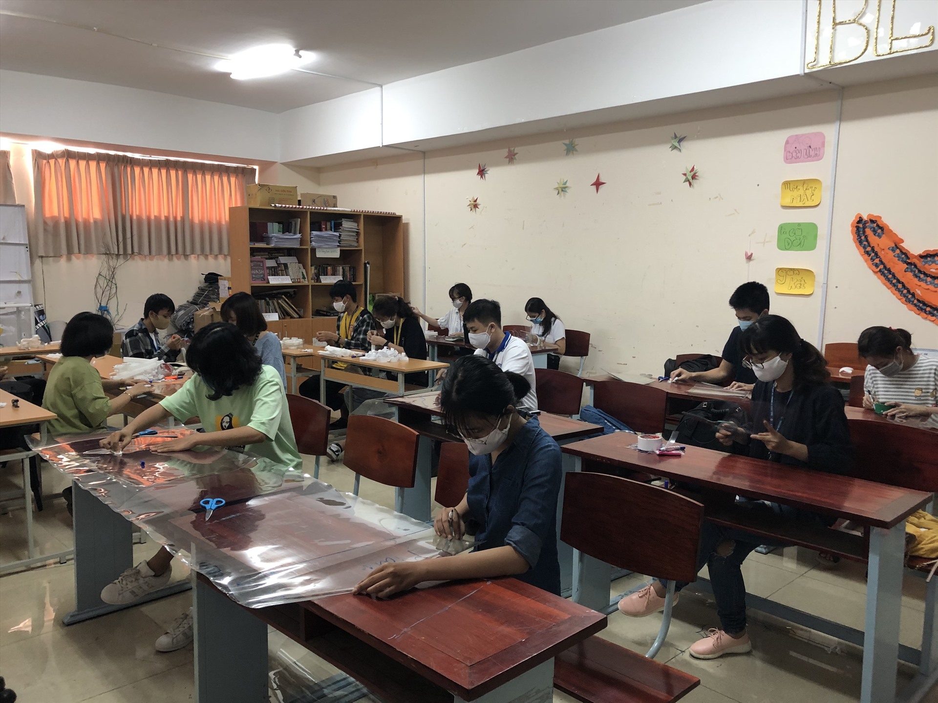 Các bạn đã chia nhau mỗi người thực hiện một khâu như người đo, đánh dấu, người cắt, người hoàn thiện sản phẩm. Ảnh: NV