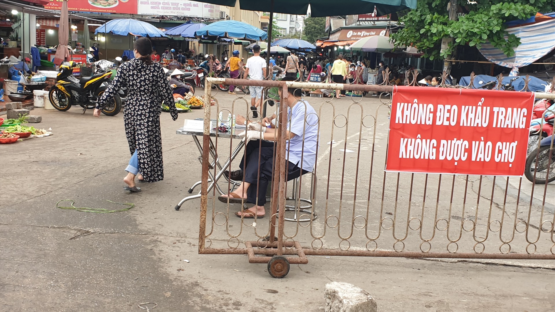 Ngoài việc đo thân nhiệt, sát trùng tay, người vào chợ bắt buộc phải đeo khẩu trang. Ảnh: Nguyễn Hùng