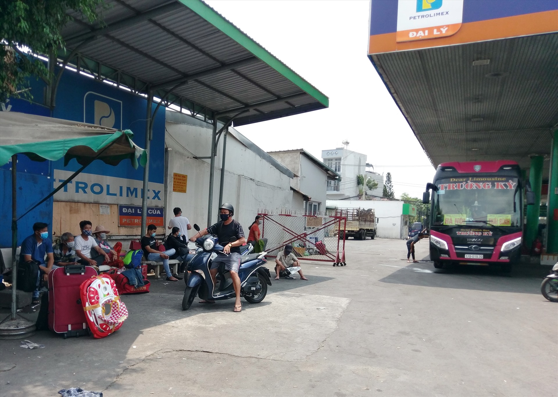 Nhiều người dân chờ lên xe dù tại một cây xăng trên quốc lộ 1A qua quận Thủ Đức (TPHCM). Ảnh: Minh Quân