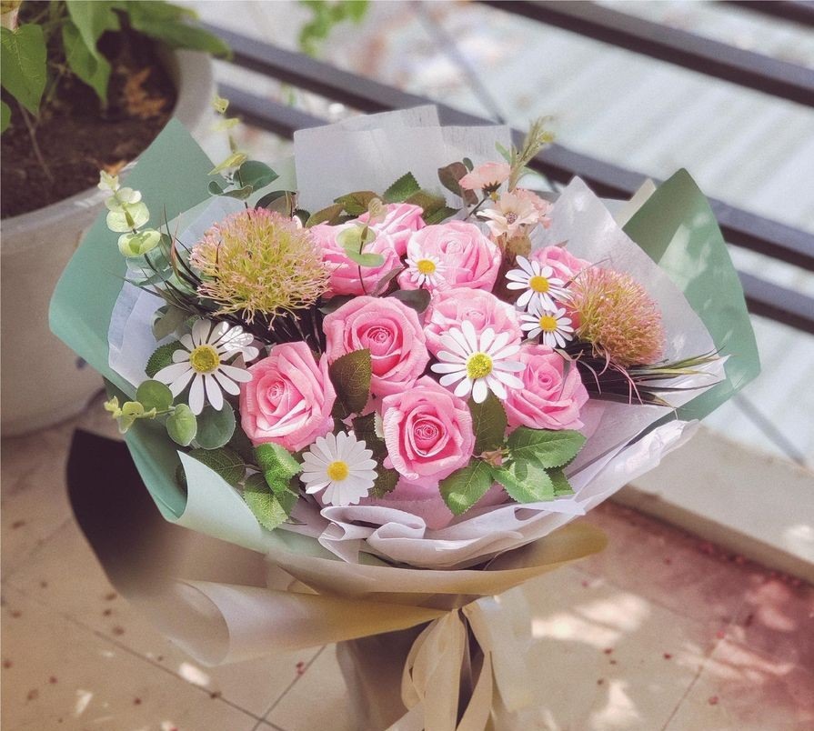Tỉ mỉ tự tay làm những bông hoa giấy sẽ nói lên tấm lòng của mình với người thương. Ảnh: T. L.