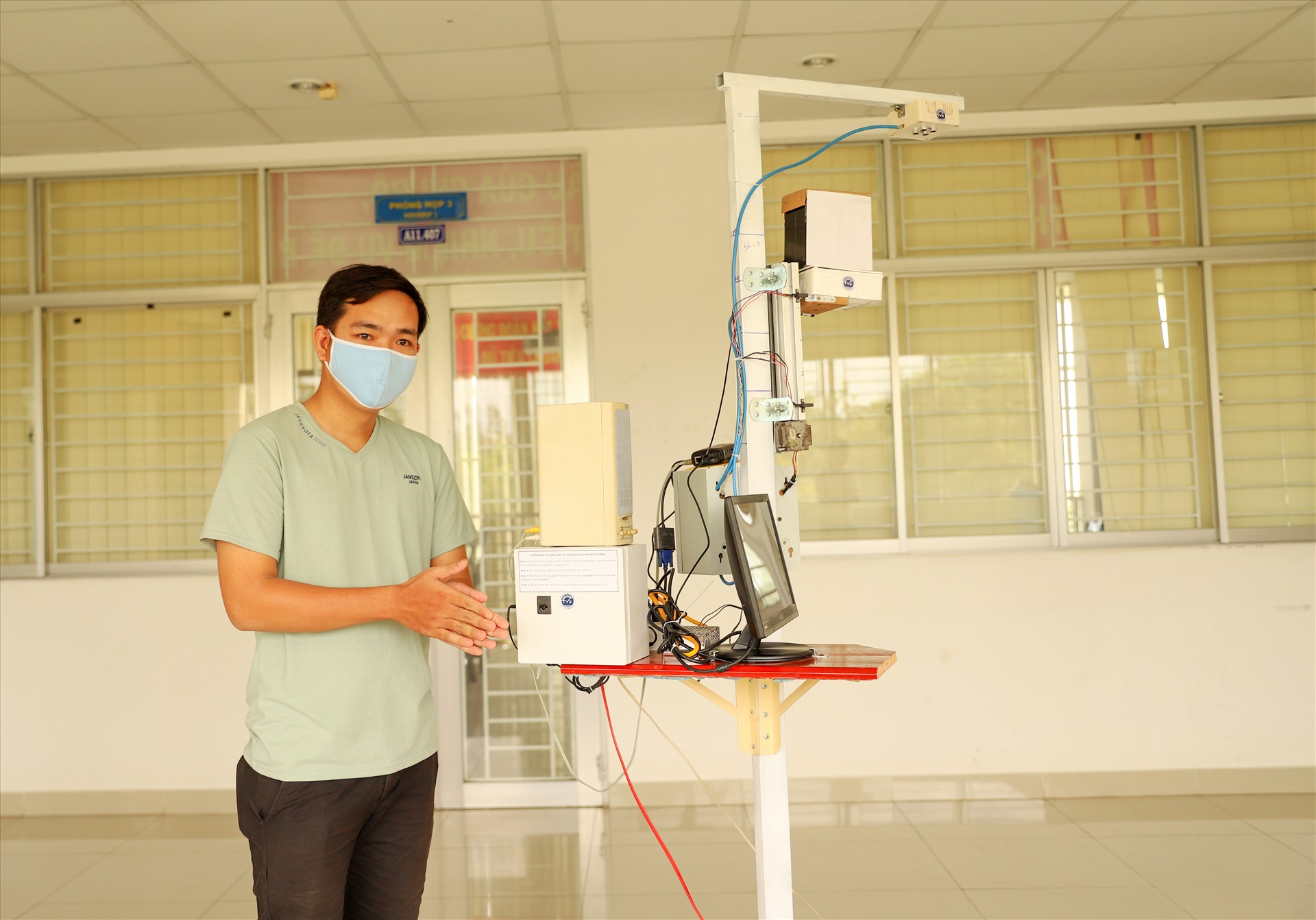 Một sinh viên của trường ĐH Trà Vinh đang được máy sát khuẩn tự động sau khi đo thân nhiệt từ xa. Ảnh: P.V.