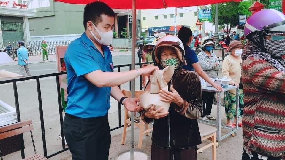 Một người bán vé số vui mừng khi nhận được gạo miễn phí. Ảnh: Linh Xong