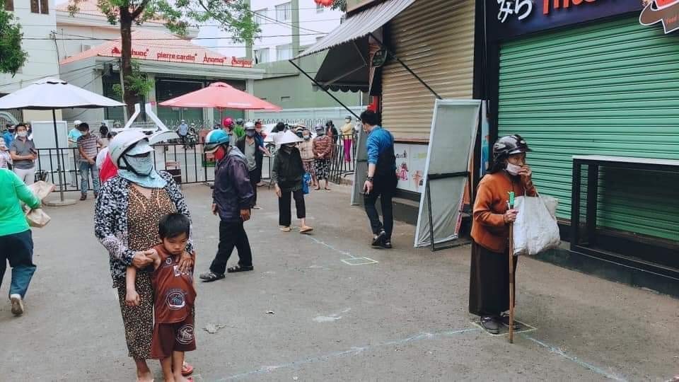 Để nhận gạo, người dân phải giữ khoảng cách, đảm bảo phòng chống COVID-19. Ảnh: Linh Xong