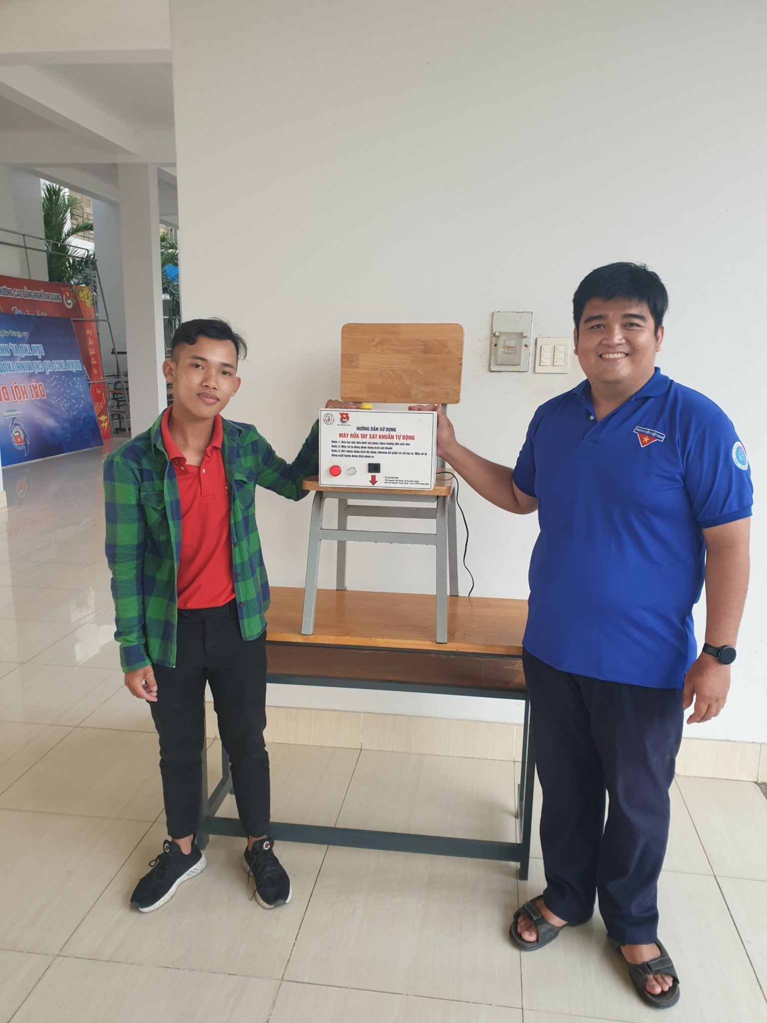 Nguyễn Thanh Phong (phải) bên sản phẩm máy rửa tay sát khuẩn tự động của mình. Ảnh: Cẩm Tú