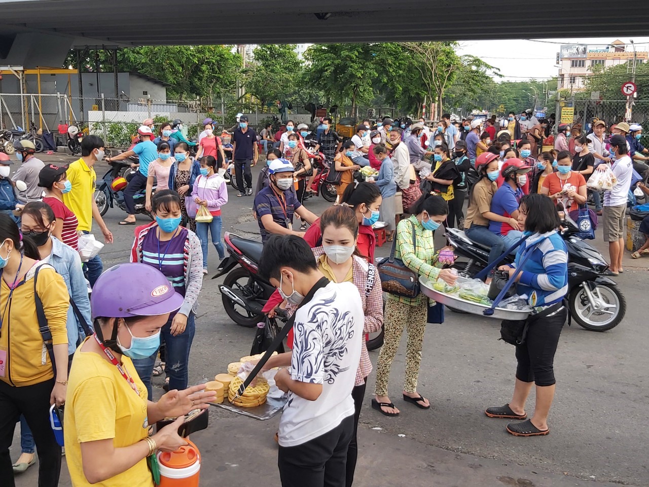 Việc mua bán đồ ăn sáng của những nghười bán hàng rong vẫn còn khá nhiều trước cổng công ty. Ảnh Đức Long