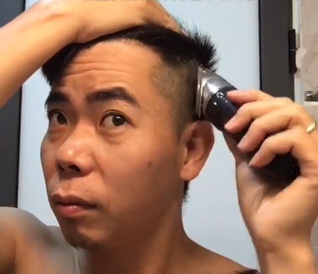 Tự tin với khả năng của mình, anh Trọng tự cắt tóc. Ảnh cắt từ clip.