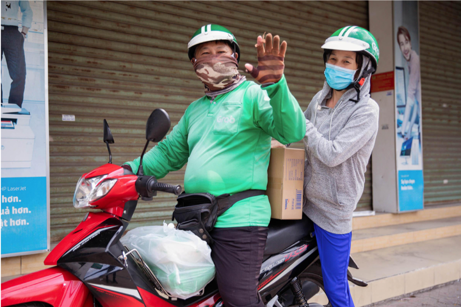 Một đối tác tài xế phấn chấn cùng vợ chở về gạo và mì vừa nhận được từ Grab.