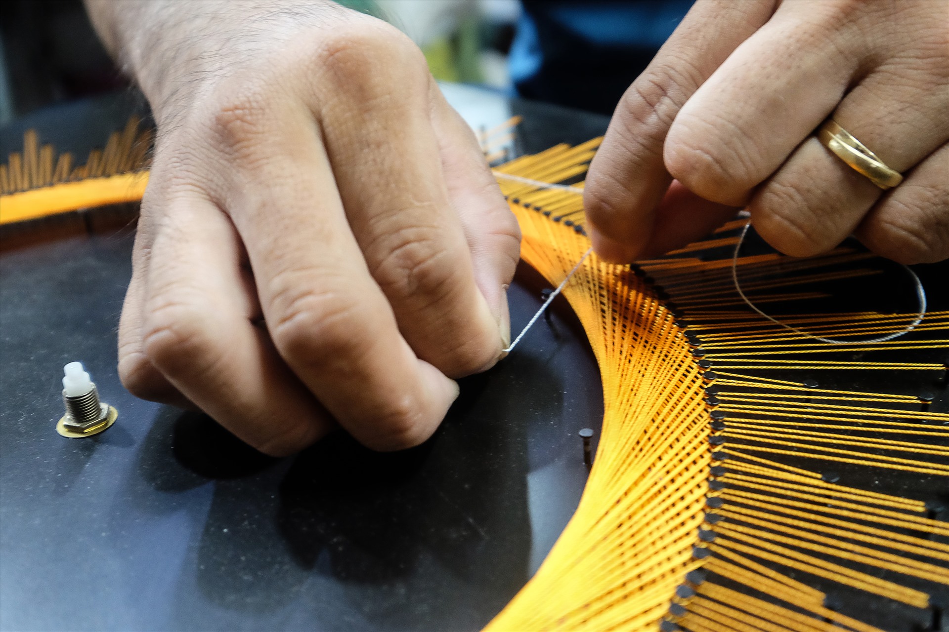 Công đoạn cột chỉ vào các trụ đinh đòi hỏi sự khéo léo và đều tay.