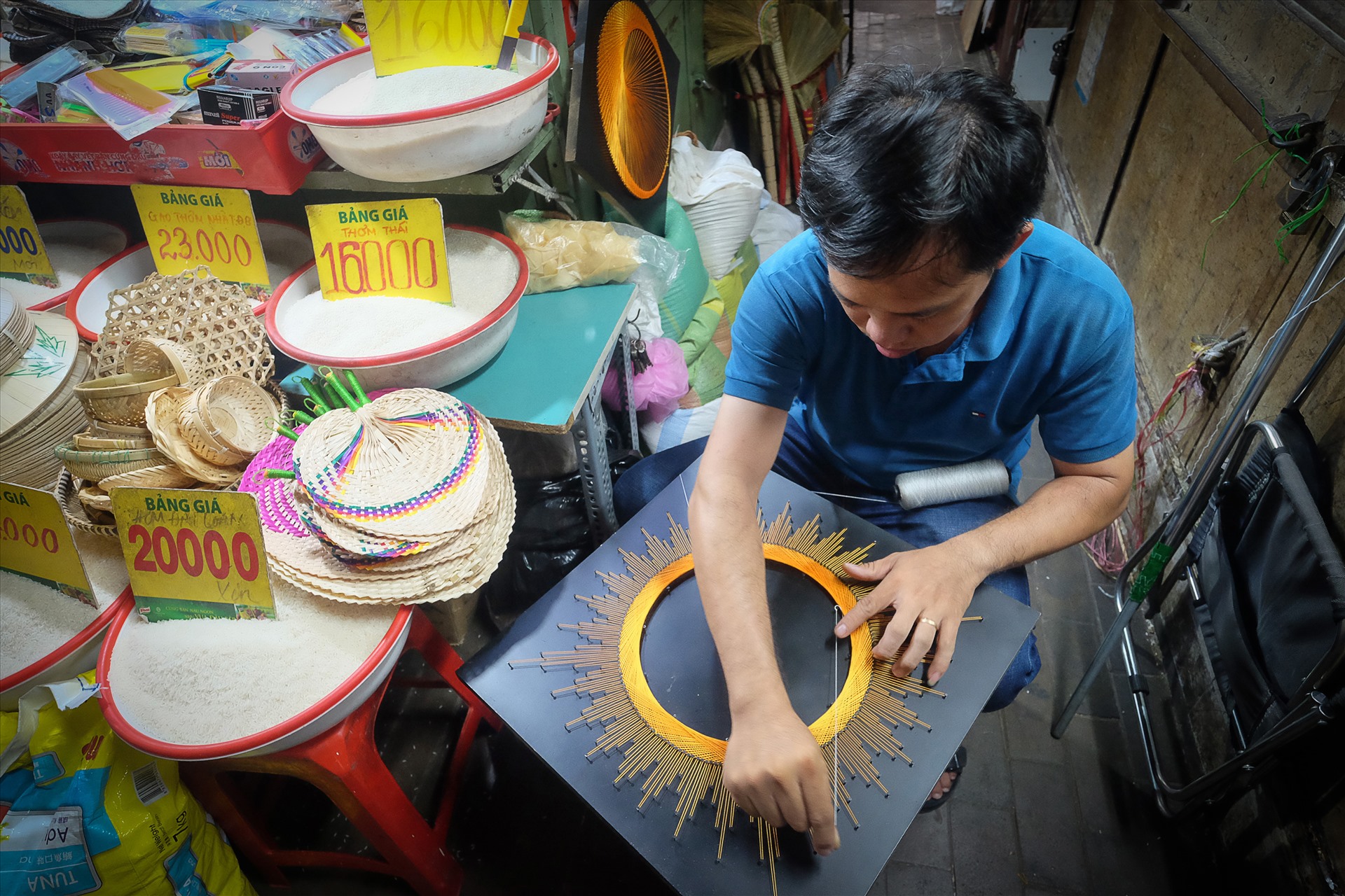 Khi vắng khách đi chợ, anh Thành lại làm tranh đinh chỉ.