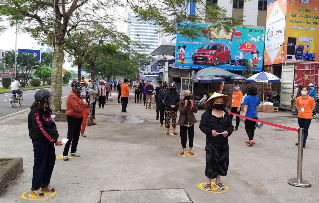 Từ 9h sáng, nhiều người dân xếp hàng chờ nhận gạo từ cây ATM. Ảnh Đặng Luân