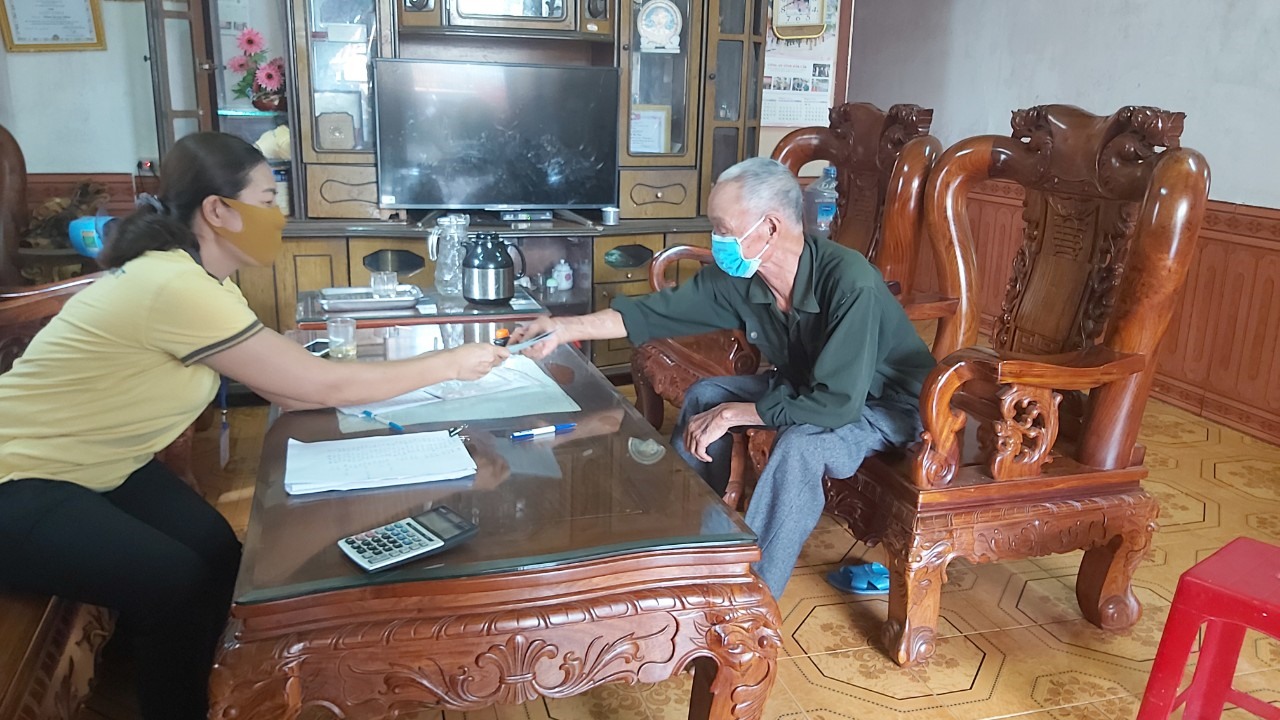 Thực hiện đeo khẩu trang trong suốt quá trình chi trả, giữ khoản cách an toàn giữa người hưởng với nhân viên chi trả. Ảnh