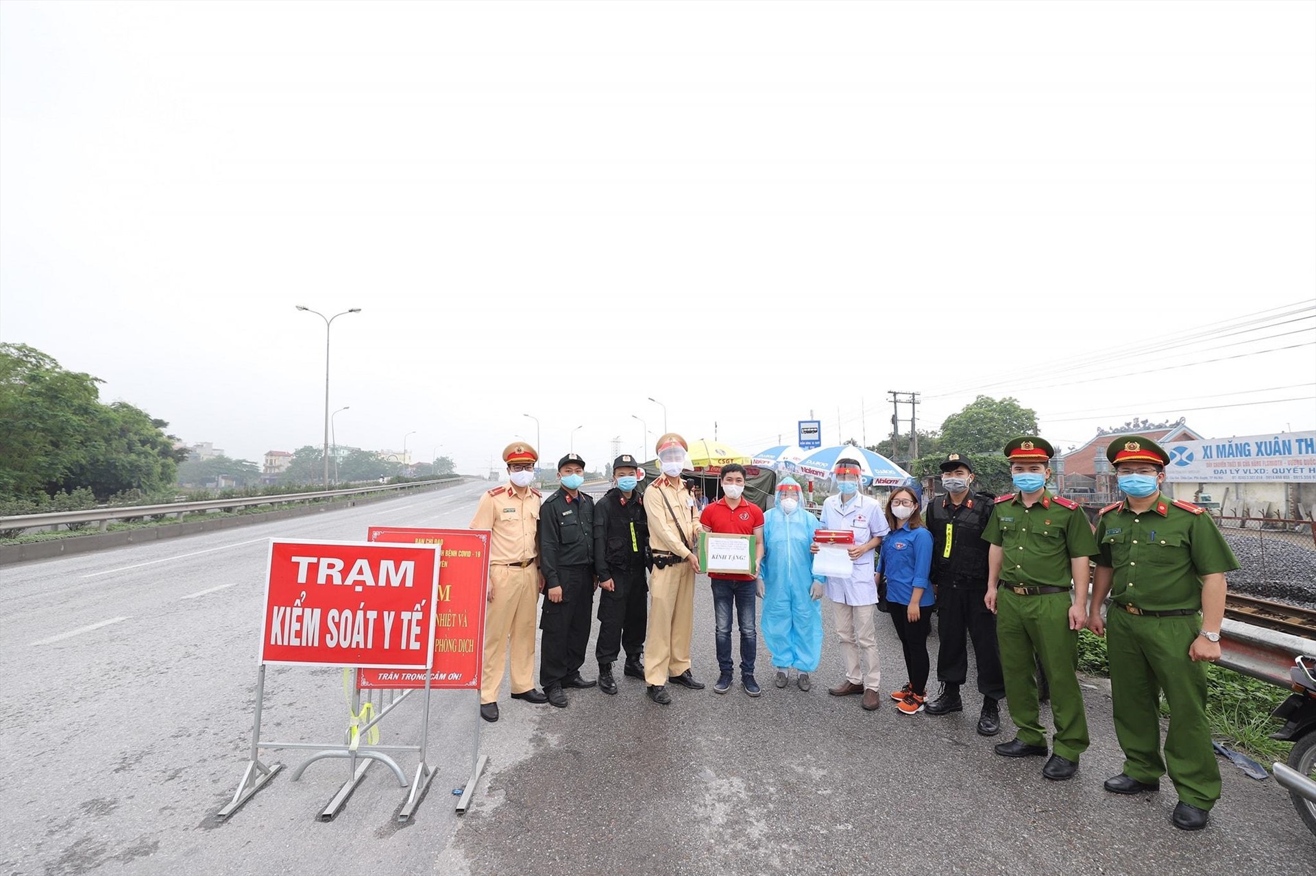 Các thành viên trong nhóm đang trao tặng mũ cho một trạm kiểm soát Y tế. Ảnh: NVCC