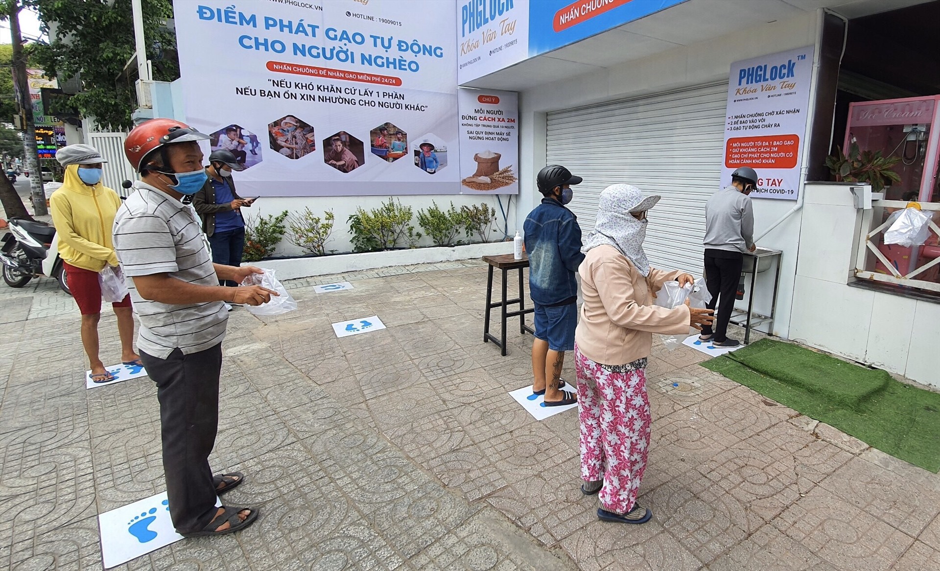 Người dân nhận gạo tại điểm phát trên đường Vườn Lài, quận Tân Phú.